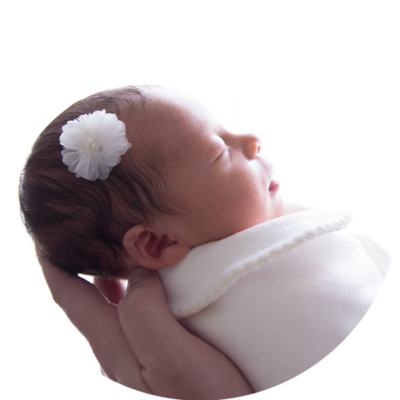 Imagem de bebê, com uma mão segurando por baixo.